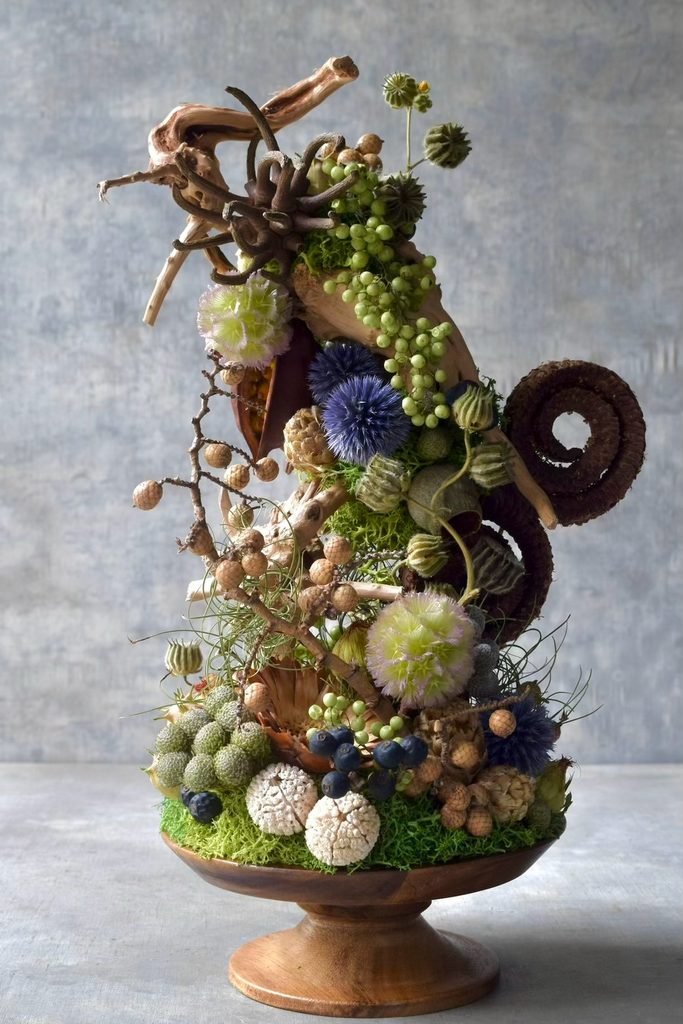 叢屋が制作するボタニカルオブジェ。流木や苔、植物が複雑に絡み合う小さな世界を木製台座に表現し、深い森の一角を切り取ったような作品に仕上げています。