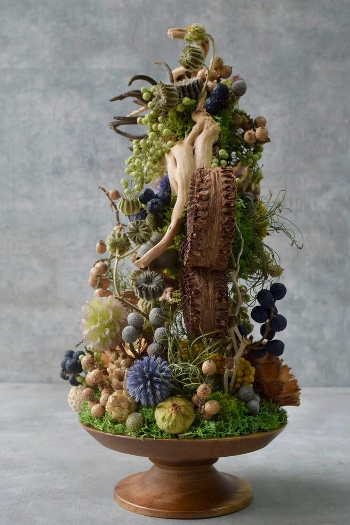 叢屋が制作するボタニカルオブジェ。流木や苔、植物が複雑に絡み合う小さな世界を木製台座に表現し、深い森の一角を切り取ったような作品に仕上げています。