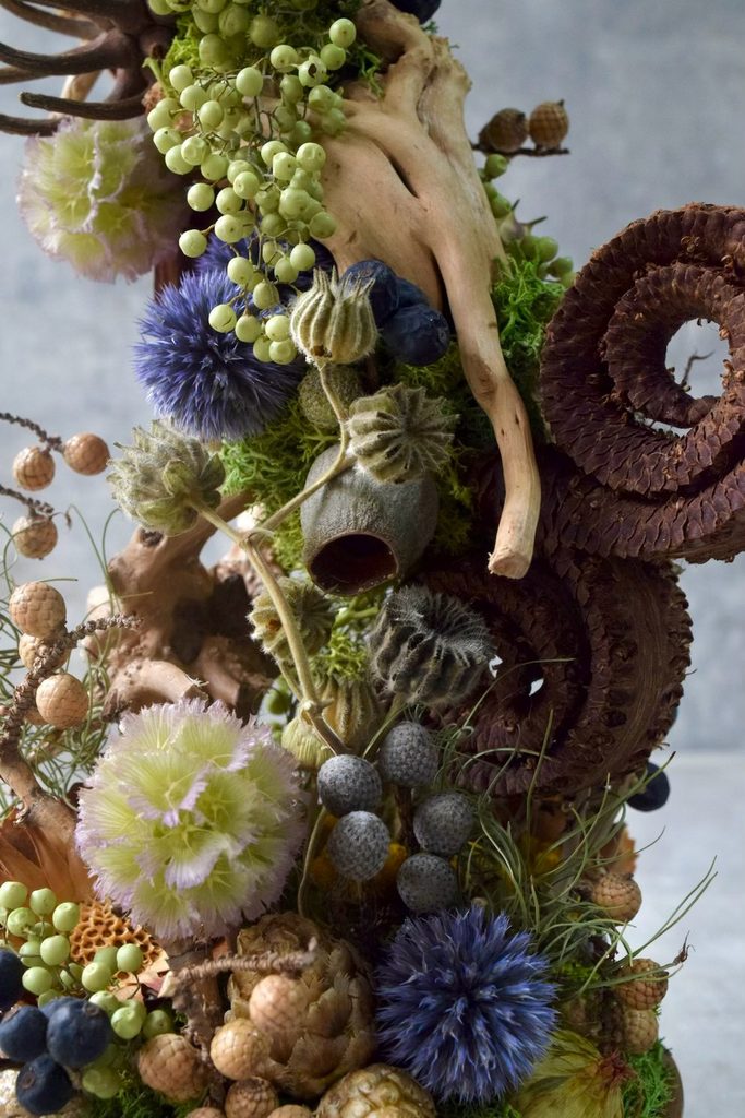 叢屋が制作するボタニカルオブジェ。流木や苔、植物が複雑に絡み合う小さな世界を木製台座に表現し、深い森の一角を切り取ったような作品に仕上げています。