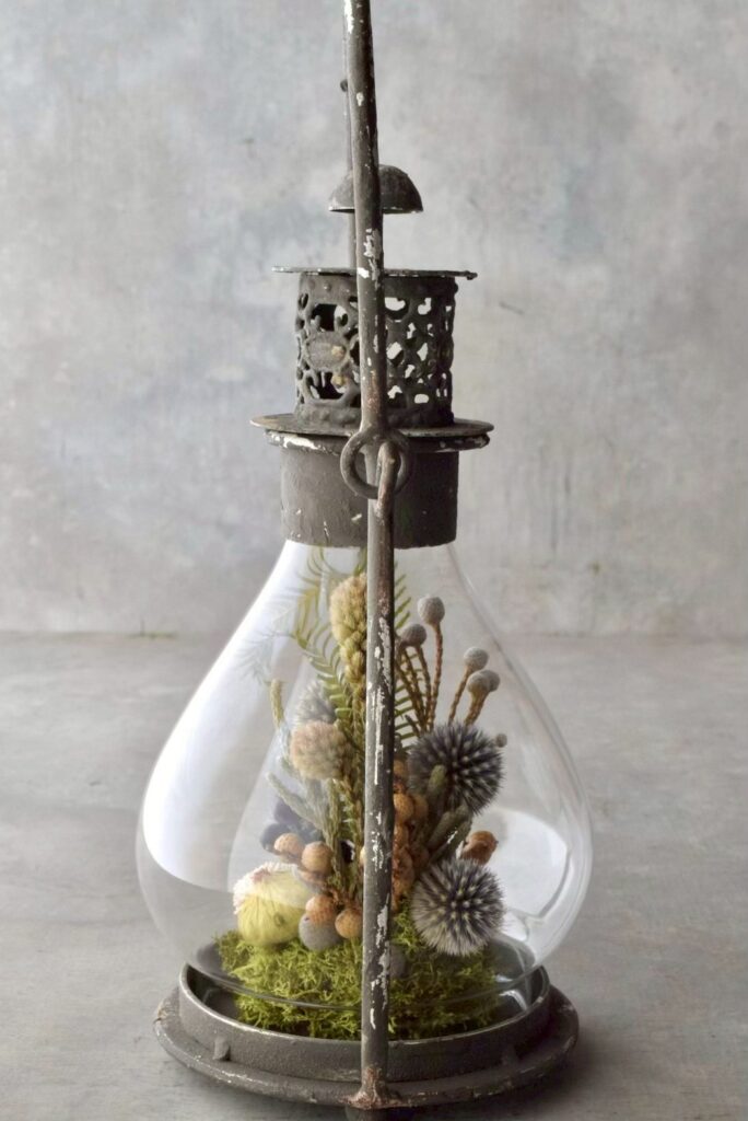 叢屋が手がけるシャビーな風合いのランタン内部にドライフラワーが詰まったボタニカルインテリア。