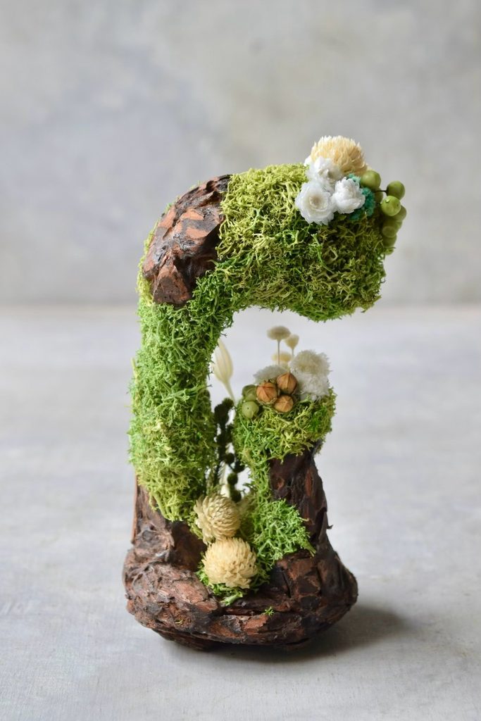 叢屋のドライフラワーを用いて、鬱蒼とした植物群が広がる深い森の一角を切り取ったようなボタニカルオブジェ。苔や木皮を組み合わせ、植物が群生する森の景色をジオラマのように立体的に表現しました。
