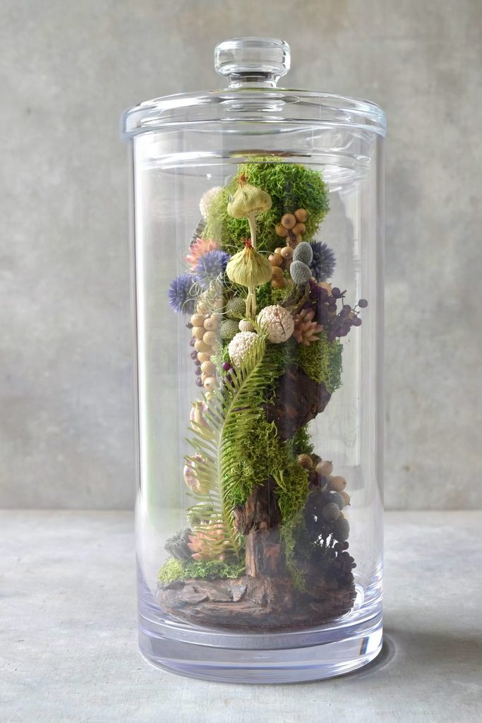 叢屋のドライフラワーを用いて、鬱蒼とした植物群が広がる深い森の一角を切り取ったようなボタニカルオブジェ。苔や木皮を組み合わせ、植物が群生する森の景色をジオラマのように立体的に表現しました。