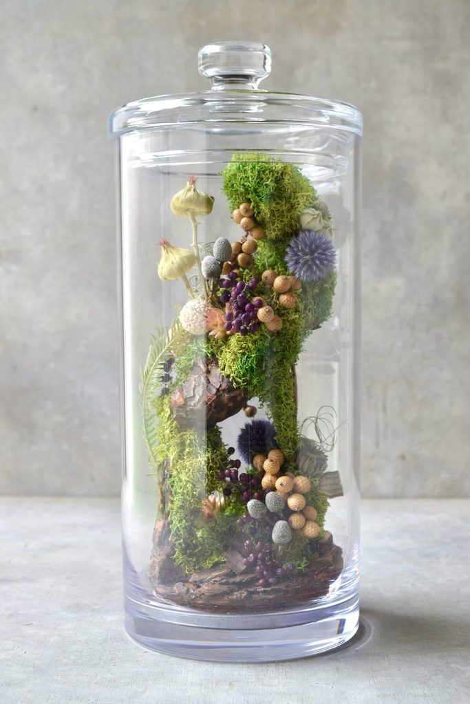 叢屋のドライフラワーを用いて、鬱蒼とした植物群が広がる深い森の一角を切り取ったようなボタニカルオブジェ。苔や木皮を組み合わせ、植物が群生する森の景色をジオラマのように立体的に表現しました。